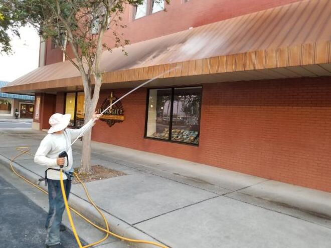 Edwin's Pressure Washing team removing dirt and rut from a commercial roof property
